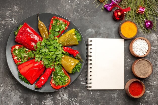 Bovenaanzicht schotel paprika met kruiden kleurrijke kruiden kerstboom speelgoed witte notebook
