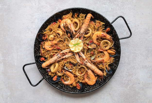 Bovenaanzicht shot van heerlijke Paella met zeevruchten en uienringen