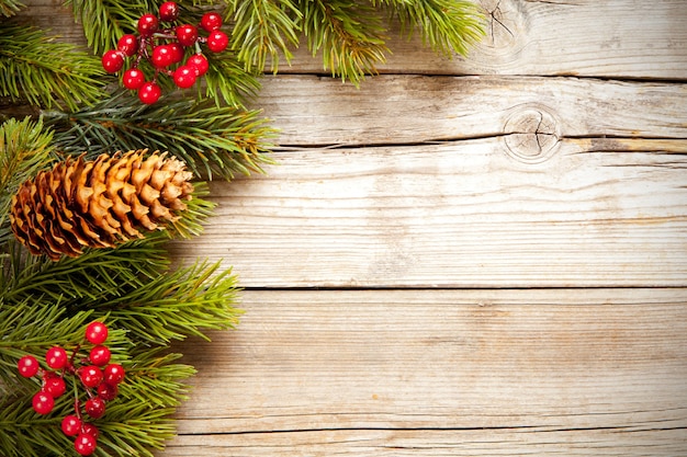 Bovenaanzicht shot van kerstboomtakken met maretak en een dennenappel op een houten oppervlak