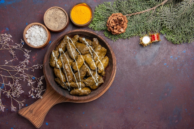 Bovenaanzicht smakelijk blad dolma vleesgerecht met kruiden in het donker