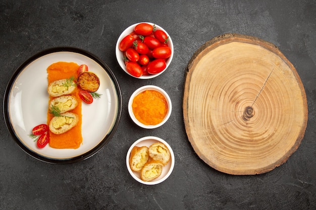 Bovenaanzicht smakelijke aardappeltaarten met pompoen en verse tomaten op de grijze achtergrond diner oven bak kleur schotel slice