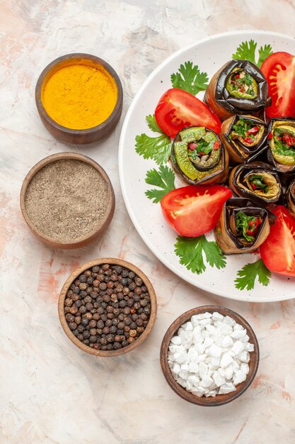 Bovenaanzicht smakelijke auberginerolletjes met groene tomaten en kruiden