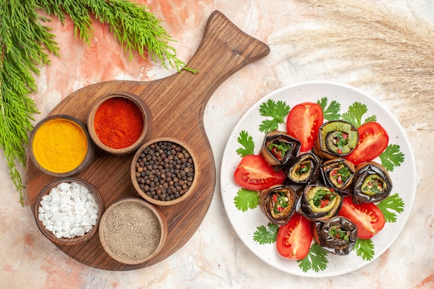 Bovenaanzicht smakelijke auberginerolletjes met tomaten en kruiden