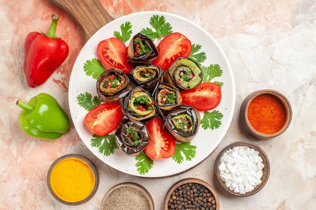 Bovenaanzicht smakelijke auberginerolletjes met tomaten en verschillende smaakmakers