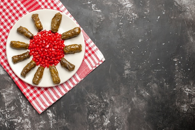 Bovenaanzicht smakelijke blad dolma met rode granaatappels op donkere achtergrond