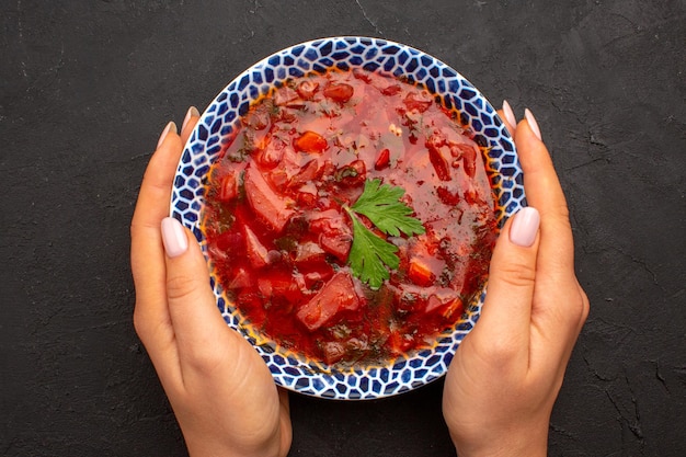 Bovenaanzicht smakelijke borsch Oekraïense bietensoep op donkere ruimte