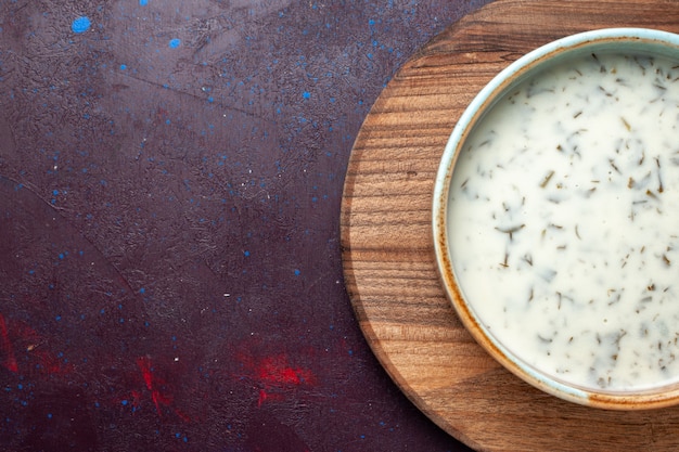 Bovenaanzicht smakelijke dovga van yoghurt met greens binnen op de donkere tafel, maaltijd eten soep groen diner