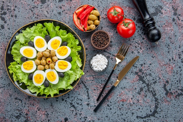 bovenaanzicht smakelijke eiersalade met kruiden en olijven op lichte achtergrond