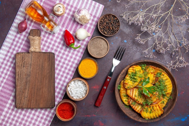 Bovenaanzicht smakelijke gekookte aardappelen heerlijk gerecht met groenten en kruiden op een donker bureau diner koken maaltijd aardappelschotel