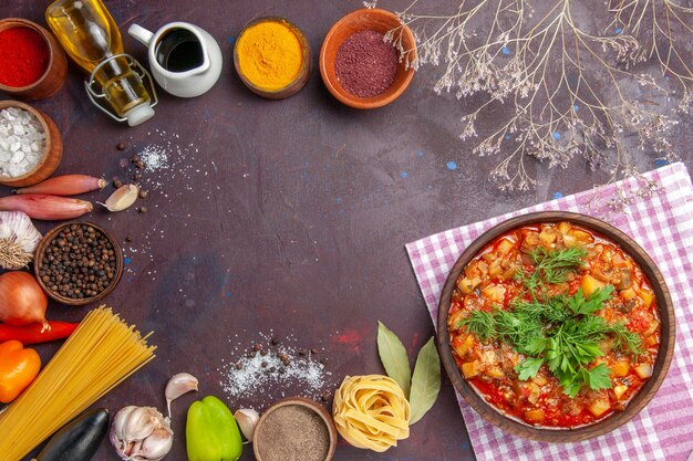 Bovenaanzicht smakelijke gekookte groenten gesneden met saus en kruiden op de donkere achtergrond saus soep eten diner maaltijd