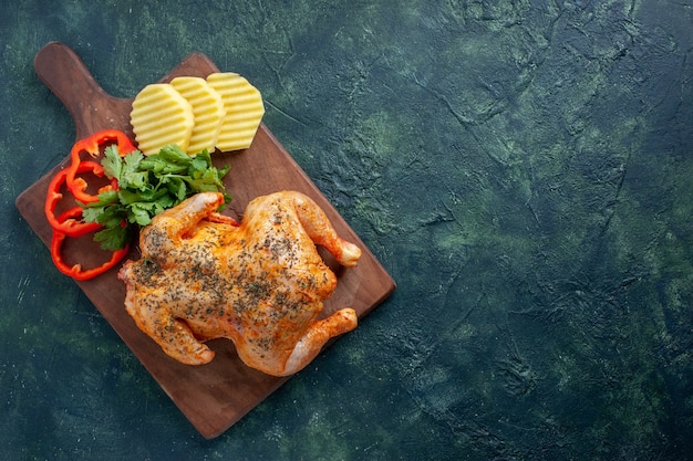 Bovenaanzicht smakelijke gekookte kip gekruid met aardappelen en gesneden peper op donkere achtergrond vleeskleur gerecht diner maaltijd eten barbecue gratis plaats