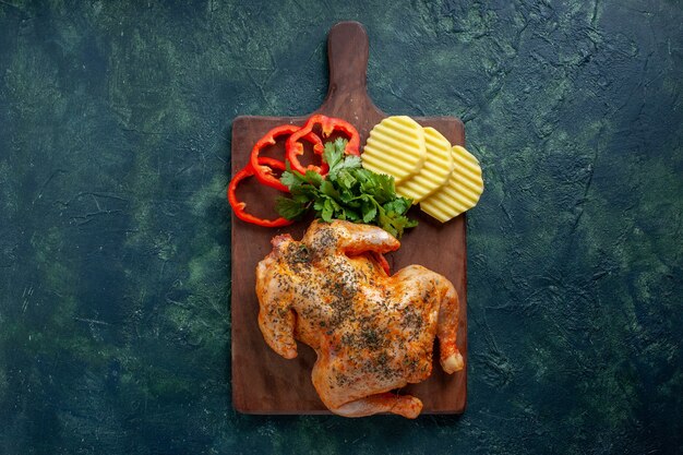 Bovenaanzicht smakelijke gekookte kip gekruid met aardappelen en gesneden peper op donkere achtergrond vleeskleur schotel diner maaltijd eten barbecue