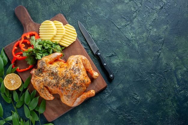 Bovenaanzicht smakelijke gekookte kip gekruid met aardappelen op de donkere achtergrond vleeskleur schotel maaltijd diner restaurant barbecue eten