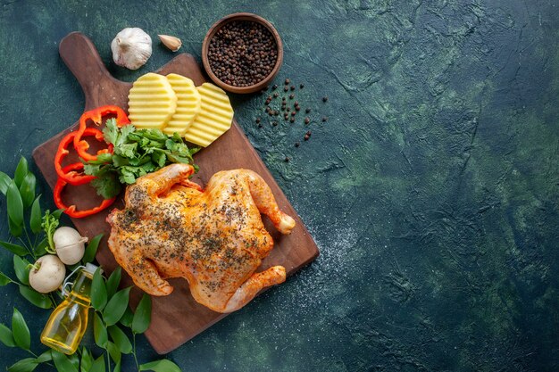 Bovenaanzicht smakelijke gekookte kip gekruid met aardappelen op donkere achtergrond vleeskleur schotel restaurant barbecue eten diner maaltijd