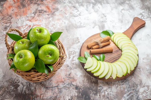 Bovenaanzicht smakelijke groene appels met gesneden fruit op de lichte achtergrond