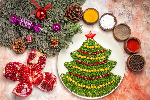 Gratis foto bovenaanzicht smakelijke groene salade in kerstboomvorm met kruiden op lichte achtergrond