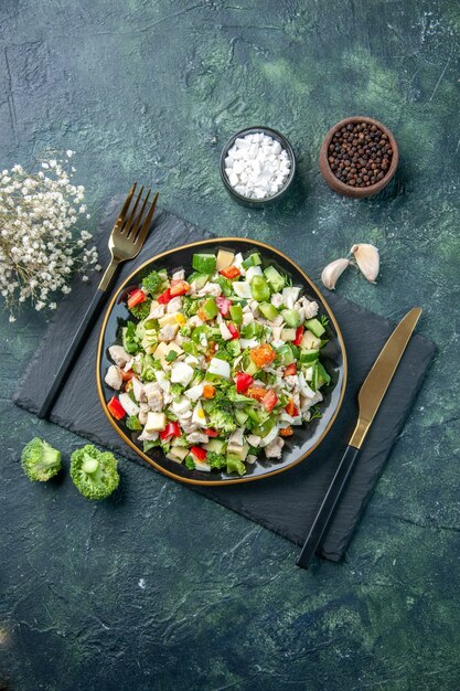 bovenaanzicht smakelijke groentesalade binnen plaat op de donkerblauwe achtergrond keuken restaurant verse maaltijd kleur gezondheid lunch voedsel dieet