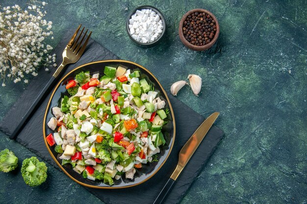 bovenaanzicht smakelijke groentesalade binnen plaat op de donkerblauwe achtergrond keuken restaurant verse maaltijd kleur gezondheid lunch voedsel dieet