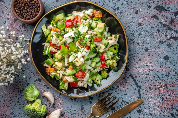 bovenaanzicht smakelijke groentesalade met bestek op donkere achtergrond voedsel restaurant kleur dieet gezondheid keuken rijp
