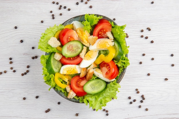 Bovenaanzicht smakelijke groentesalade met eieren op witte achtergrond voedselsalade dieet gezond leven rijpe maaltijd lunch ontbijt