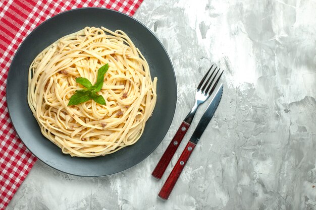 Bovenaanzicht smakelijke Italiaanse pasta met bestek op witte achtergrond
