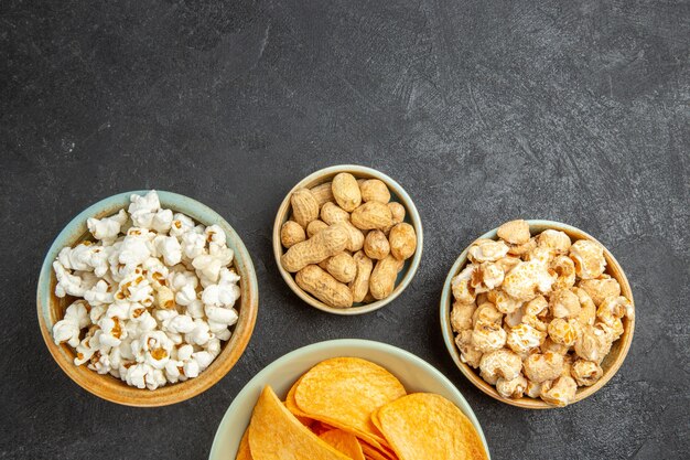 Bovenaanzicht smakelijke kaaschips met verschillende snacks op de donkere achtergrond