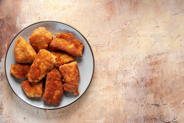 Bovenaanzicht smakelijke kippenvleugels in plaat op bruin oppervlak hamburger maaltijd lunch sandwich eten friet vlees