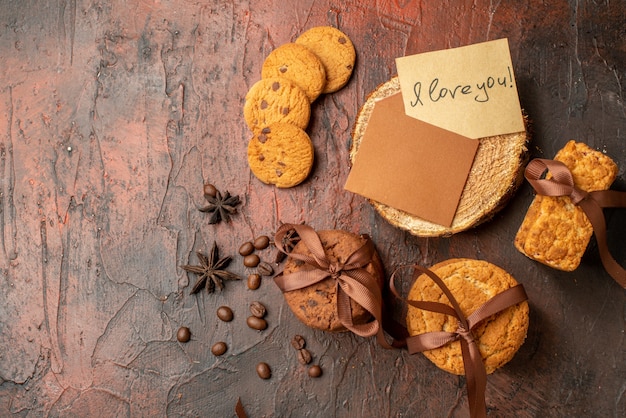 Bovenaanzicht smakelijke koekjes vastgebonden met touw koekjes anijs liefdesbrief op donkerrode tafel met