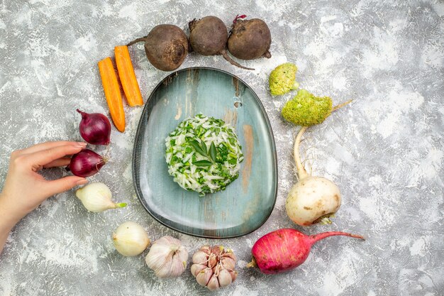 Bovenaanzicht smakelijke koolsalade met verse groenten op witte tafel