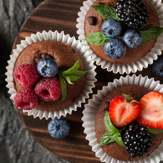 Bovenaanzicht smakelijke muffin met bosvruchten en aardbeien