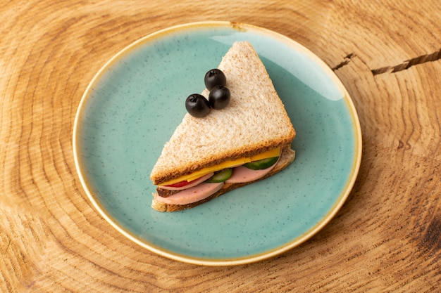 Bovenaanzicht smakelijke sandwich met olijf ham tomaten groenten in plaat op de houten achtergrond sandwich eten snack ontbijt