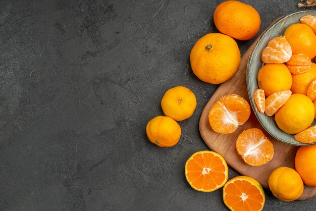 Bovenaanzicht smakelijke sappige mandarijnen binnen plaat op grijze achtergrond