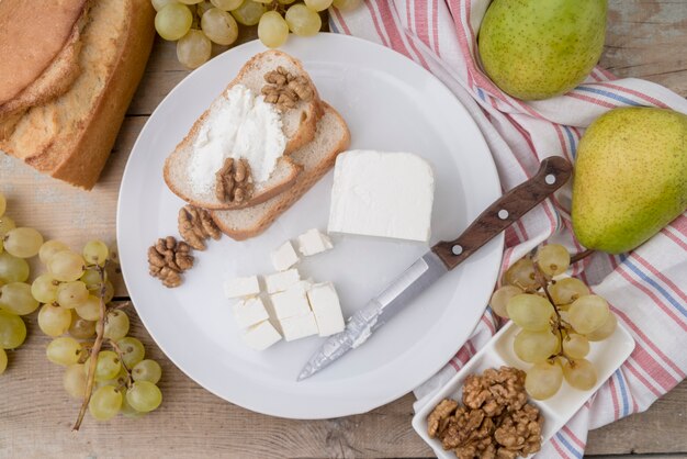 Bovenaanzicht smakelijke selectie van fruit met kaas en brood