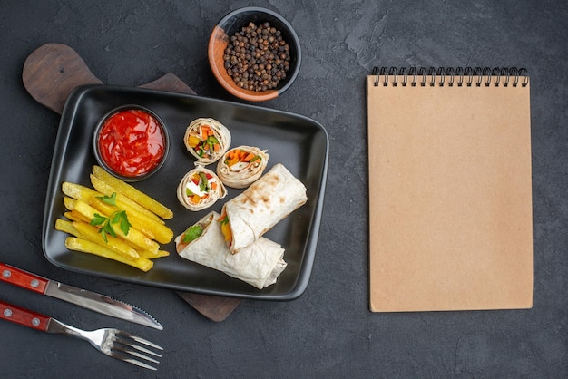 Bovenaanzicht smakelijke shaurma gesneden pitabroodje met frietjes en ketchup op donkere ondergrond hamburgers voedsel snack brood fastfood toast grill