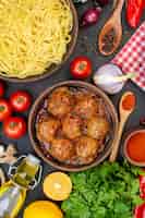 Gratis foto bovenaanzicht smakelijke spaghetti in kom gehaktbal in kom olie fles tomaten peterselie op tafel