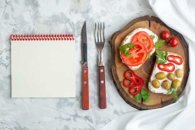 Bovenaanzicht smakelijke toast met tomaten en olijven op een houten bord witte achtergrond brood hamburger snack horizontaal voedsel lunch maaltijd diner