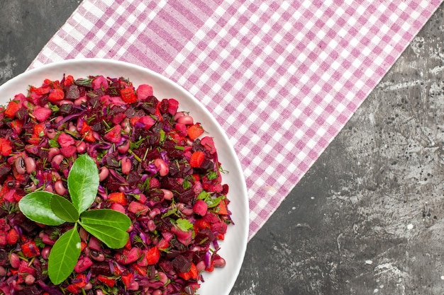 Bovenaanzicht smakelijke vinaigrette bietensalade binnen plaat op het donkere oppervlak