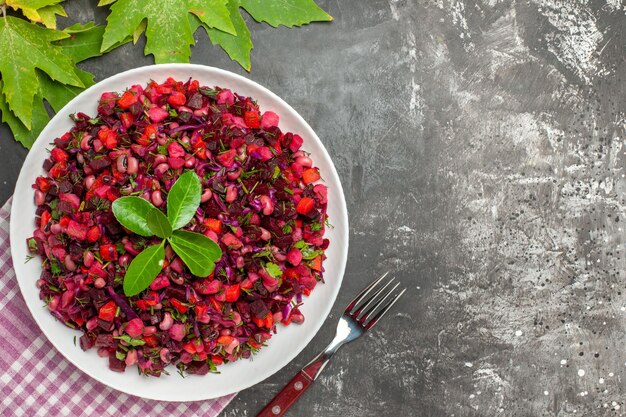 Bovenaanzicht smakelijke vinaigrette bietensalade binnen plaat op het donkere oppervlak