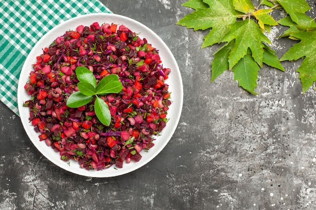 Bovenaanzicht smakelijke vinaigrette bietensalade binnen plaat op het donkere oppervlak