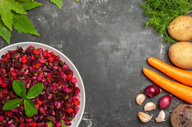 Bovenaanzicht smakelijke vinaigrette bietensalade met greens op het donkere oppervlak