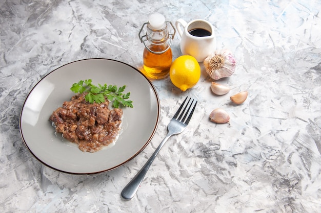 Bovenaanzicht smakelijke vleesgerecht met saus en greens op witte tafel vleesgerecht dinermaaltijd