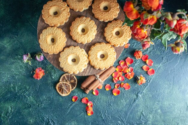 Bovenaanzicht smakelijke zoete koekjes op donkere achtergrond dessert biscuit suiker zoete pauze deeg thee cake taart bloem