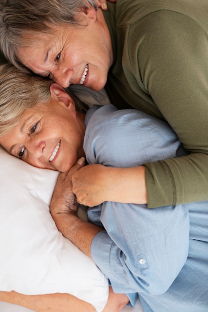 Gratis foto bovenaanzicht smileyvrouwen die in bed liggen