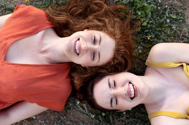 Bovenaanzicht smileyvrouwen die op gras liggen