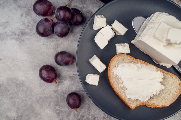 Bovenaanzicht sneetje brood met kaas en druiven