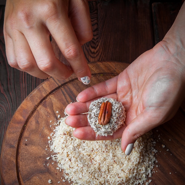 Bovenaanzicht snoep handgemaakte handgemaakte snoepjes van noten, gedroogd fruit en honing op een donkere houten ondergrond
