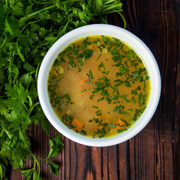 Gratis foto bovenaanzicht soep met groenten en peterselie in een witte plaat