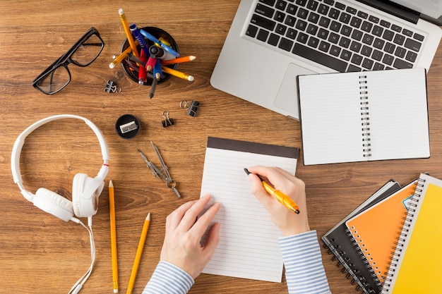 Gratis foto bovenaanzicht student schrijven op kladblok