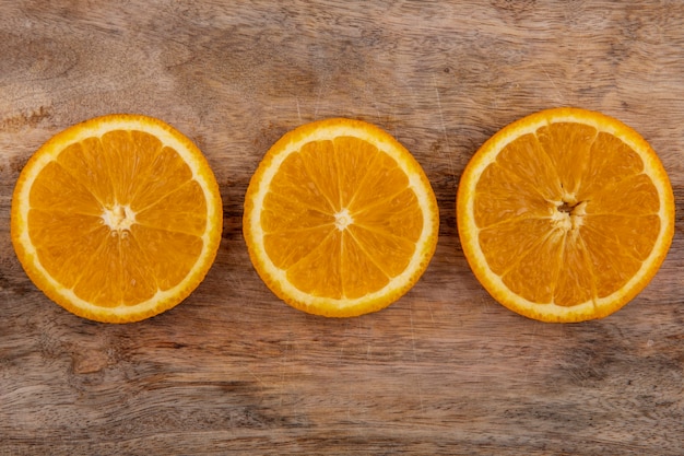 Gratis foto bovenaanzicht stukjes sinaasappel op een snijplank