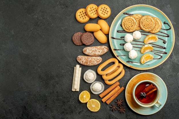 Bovenaanzicht suiker koekjes met snoepjes en kopje thee op grijze achtergrond